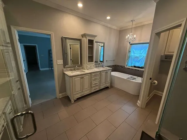 a large white kitchen with a sink a refrigerator and window