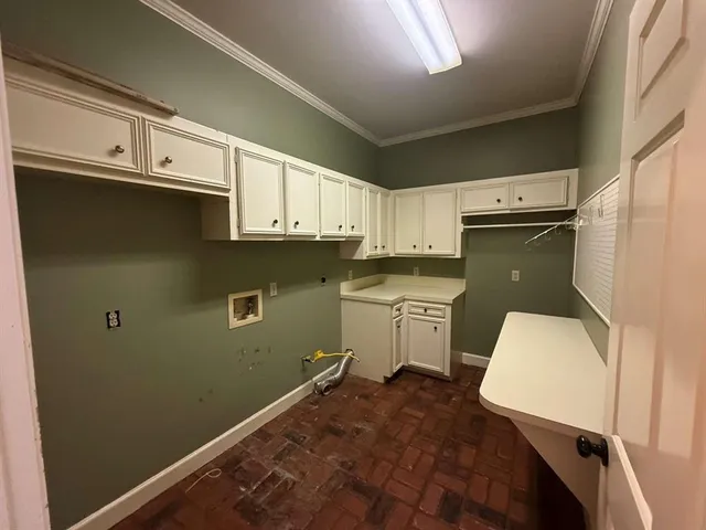 a kitchen with a refrigerator and white cabinets