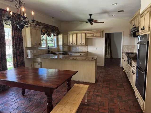 a kitchen with kitchen island a wooden floor and a refrigerator
