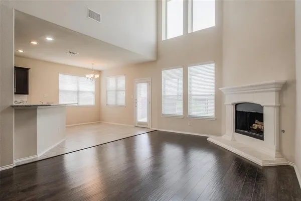 an empty room with wooden floor and fireplace