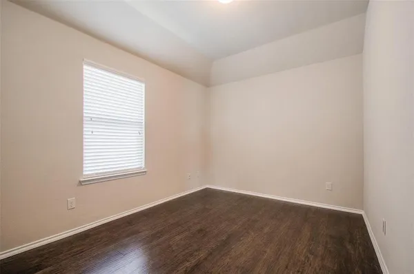an empty room with wooden floor and a window