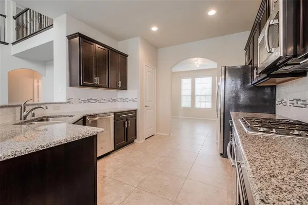 a kitchen with stainless steel appliances granite countertop a sink stove and cabinets