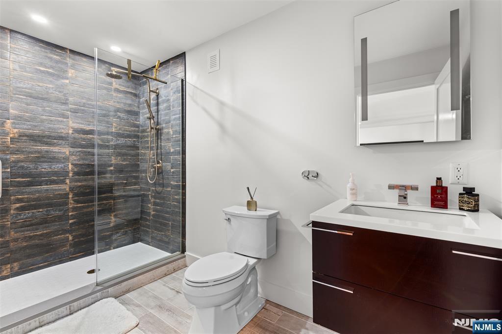 7 Oakdene Terrace, Unit 7 Edgewater, NJ 07020 - Photo 7 of 30 a bathroom with a sink a toilet and shower