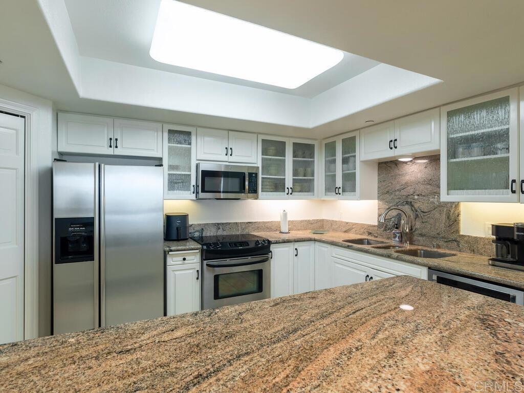 1099 1st Street, Unit 217 Coronado, CA 92118 - Photo 15 of 32 a kitchen with stainless steel appliances granite countertop a stove sink and refrigerator