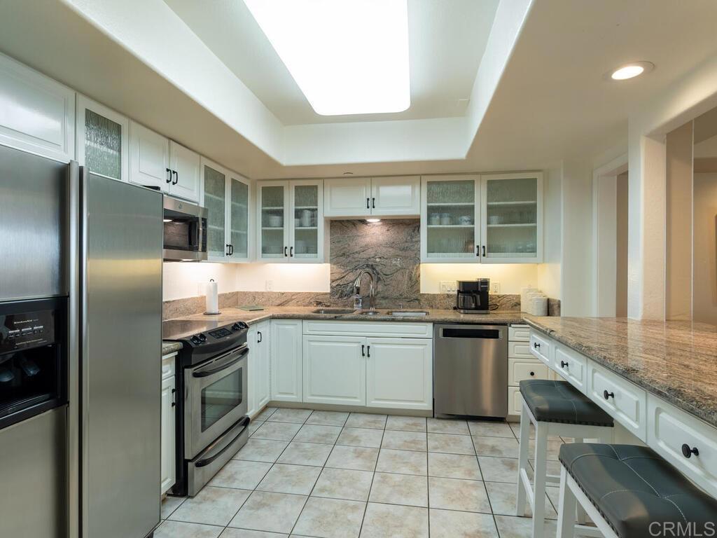 1099 1st Street, Unit 217 Coronado, CA 92118 - Photo 17 of 32 a kitchen with stainless steel appliances granite countertop a sink and stove