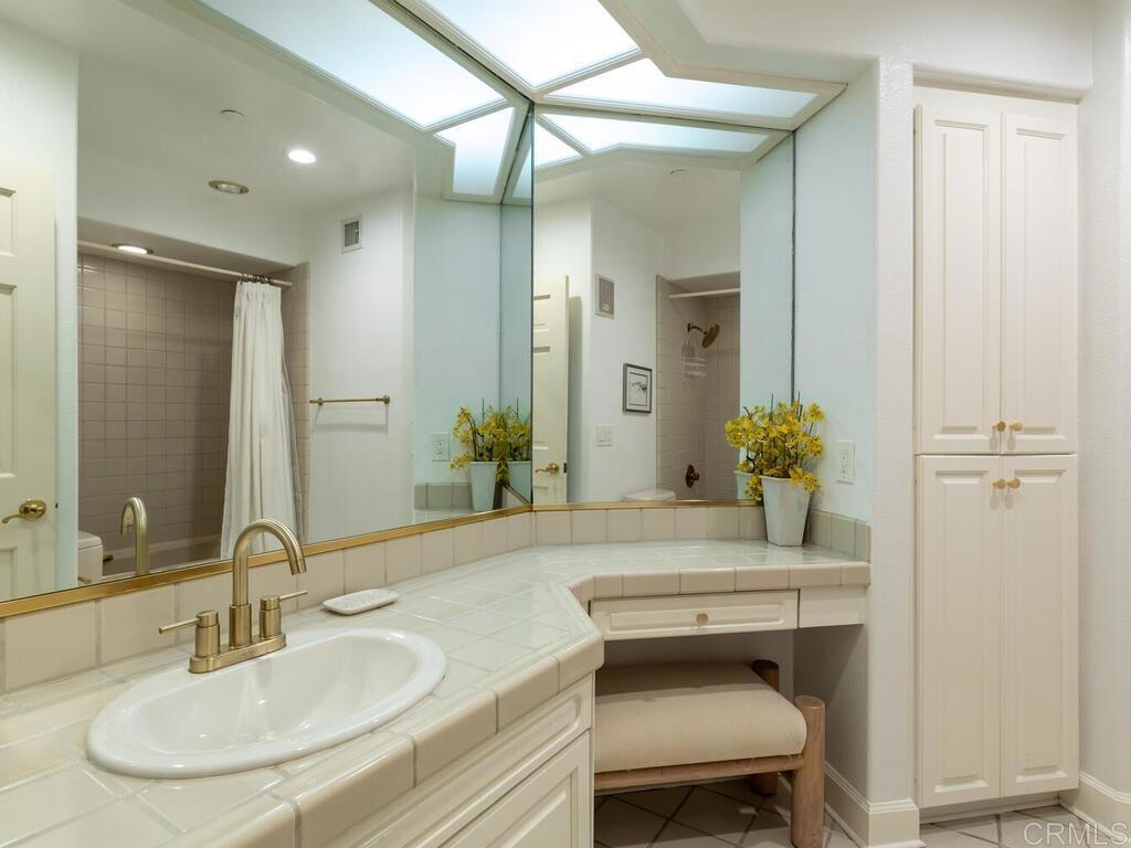 1099 1st Street, Unit 217 Coronado, CA 92118 - Photo 28 of 32 a bathroom with a granite countertop sink and a mirror