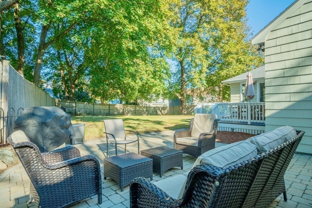 3 Elliot Road Lynnfield, MA 01940 - Photo 18 of 42 a view of a patio with couches table and chairs under an umbrella