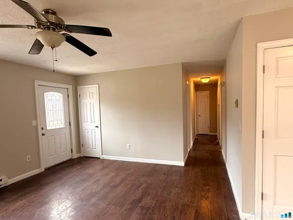 a view of a hallway with wooden floor and closet area