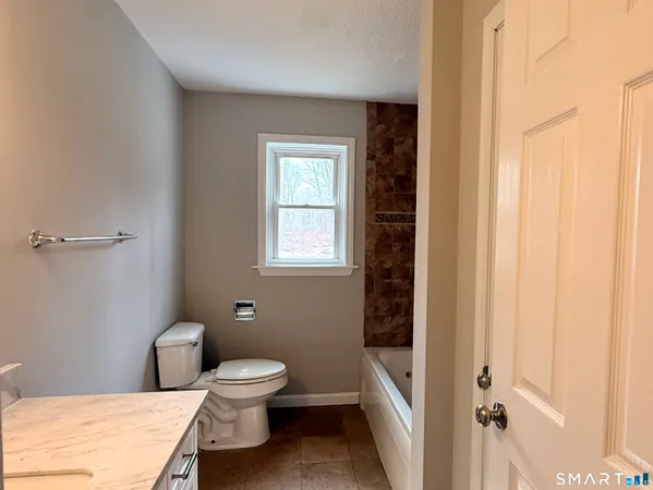 a bathroom with a toilet a sink and a window