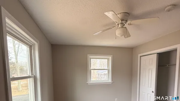 a view of a livingroom with a window and a ceiling fan