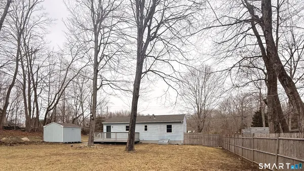 a white house that has a tree in front of it