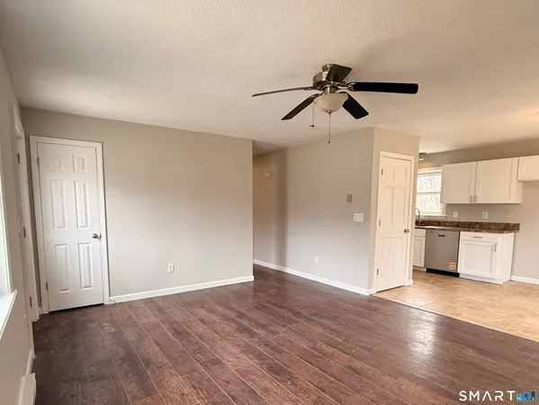 a view of empty room with wooden floor and window