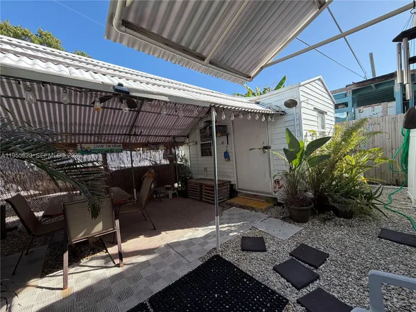 a view of a patio with table and chairs potted plants
