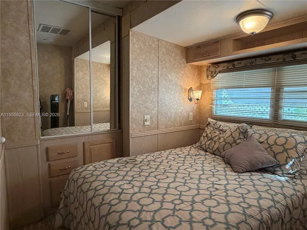 a bedroom with a large bed and a window