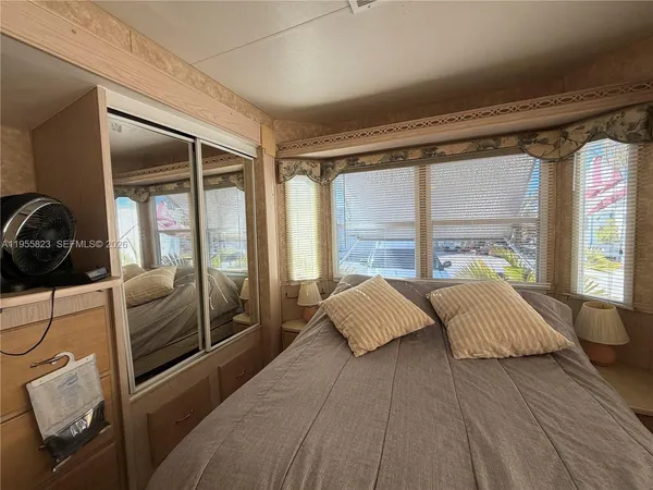 a bedroom with a bed and large window