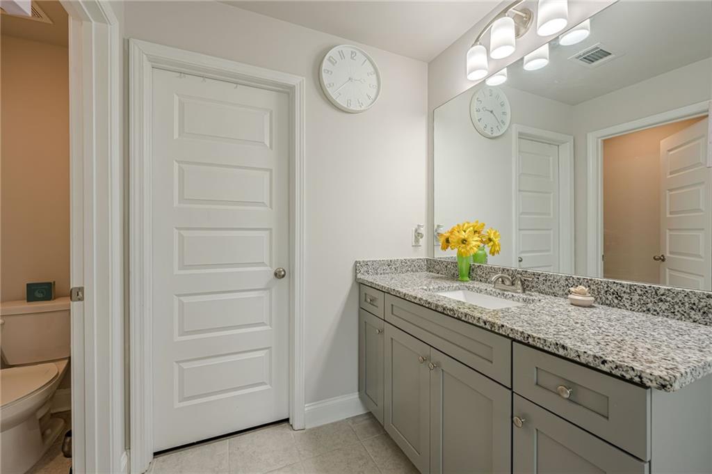 6940 Cedar Glen Road Atlanta, GA 30360 - Photo 16 of 24 a bathroom with a granite countertop sink and a mirror