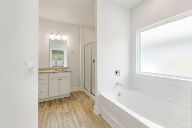 a bathroom with a bathtub a mirror a sinks and a shower