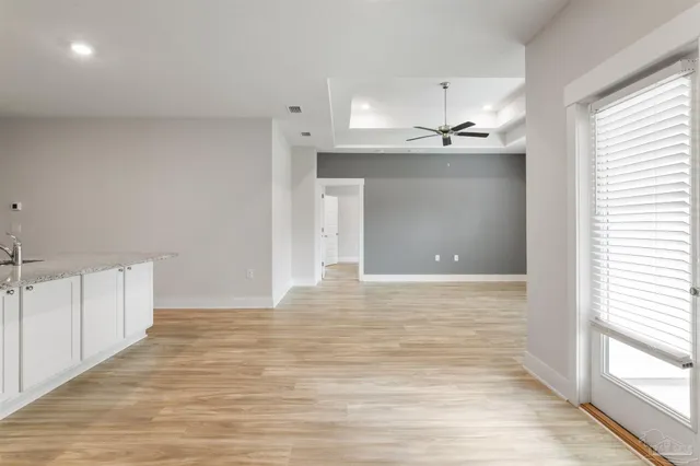 a view of a room with a ceiling fan and wooden floor