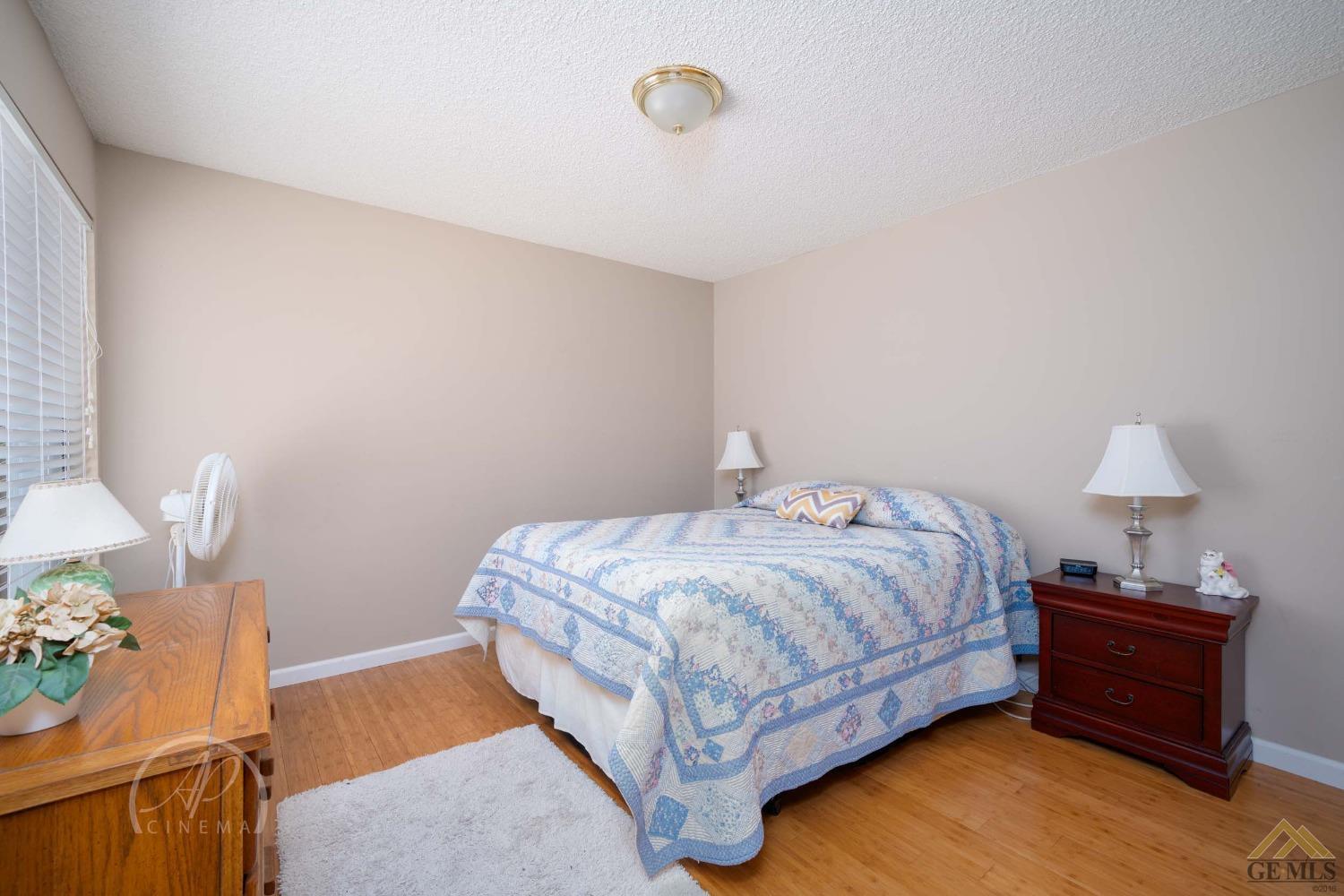 Undisclosed Address Bakersfield, CA 93309 - Photo 11 of 26 a bedroom with a bed and a lamp on the dresser