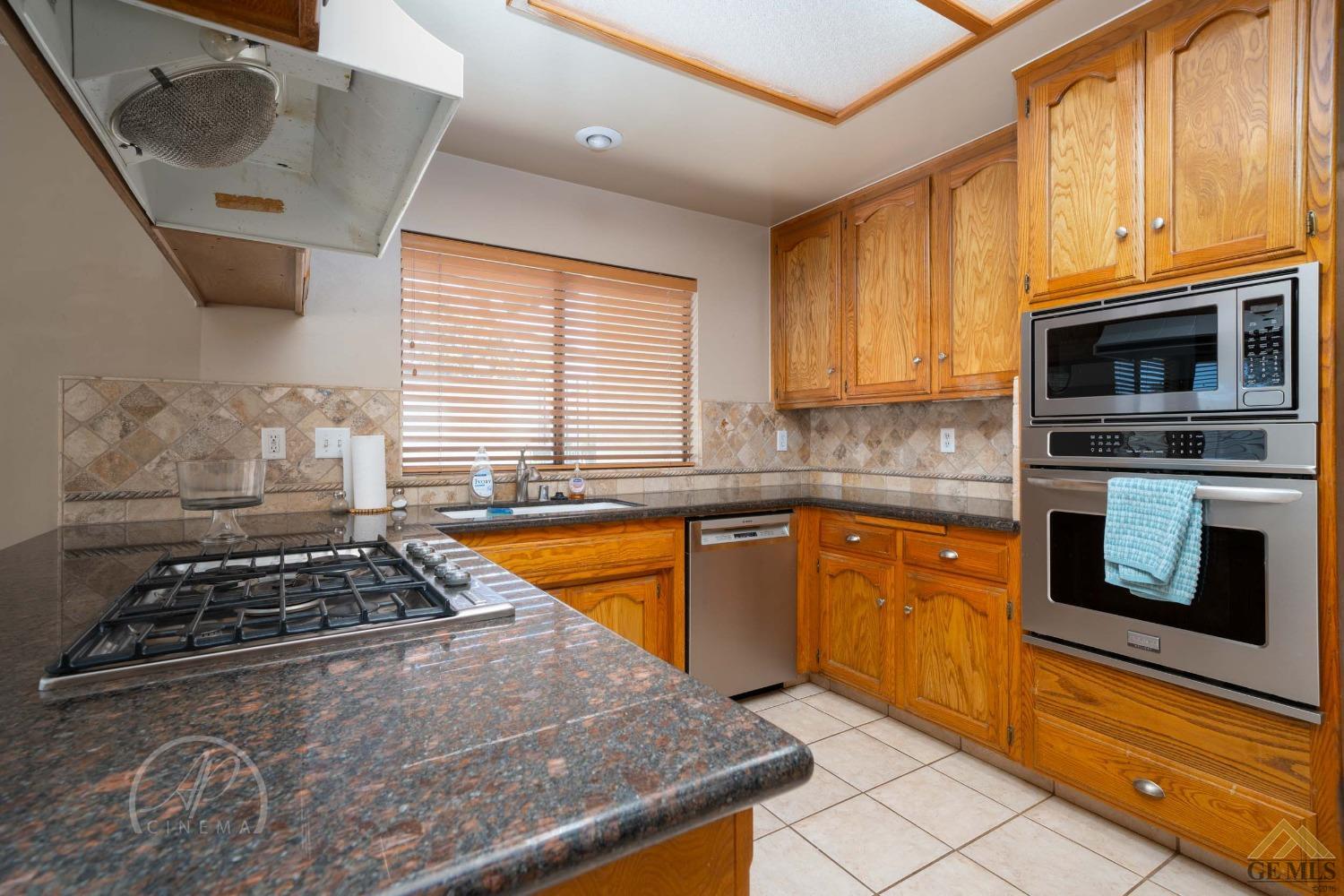 Undisclosed Address Bakersfield, CA 93309 - Photo 19 of 26 a kitchen with granite countertop a stove and a sink