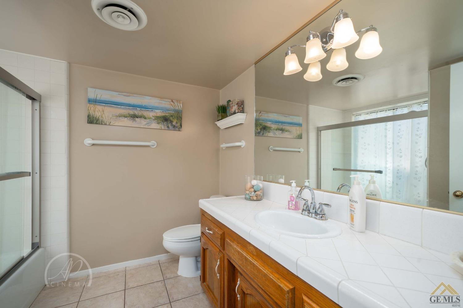 Undisclosed Address Bakersfield, CA 93309 - Photo 10 of 26 a bathroom with a sink a toilet and a mirror