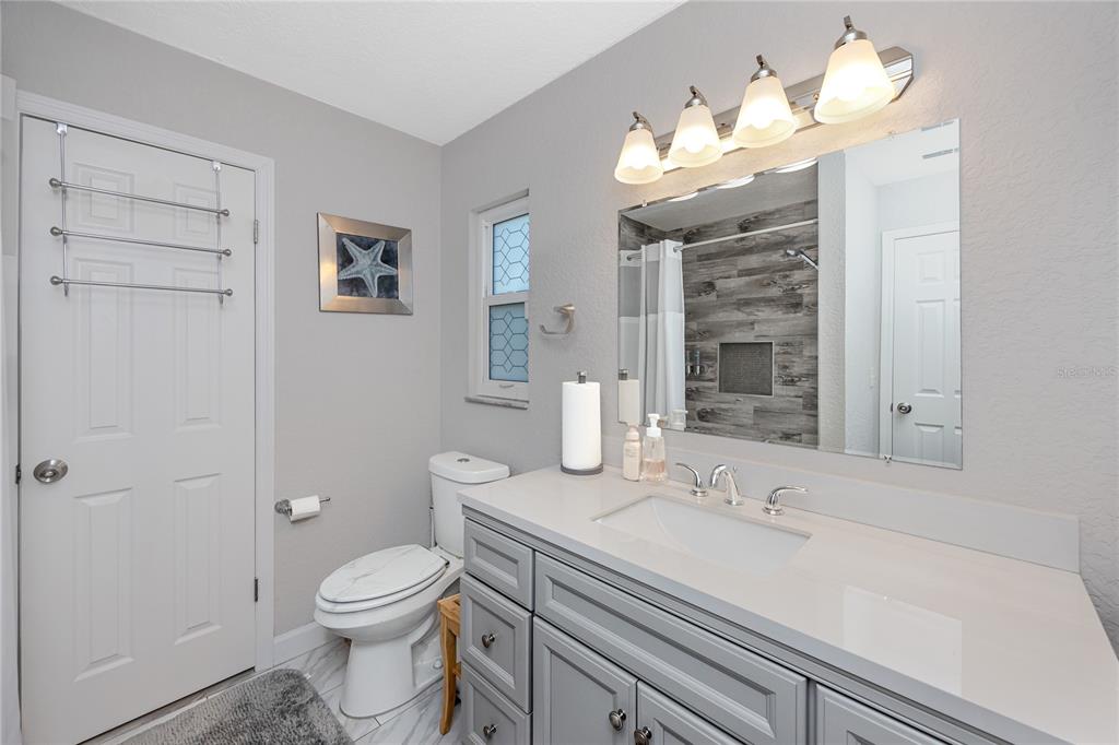 1869 Seton Drive Clearwater, FL 33763 - Photo 14 of 40 a bathroom with a sink a toilet and shower