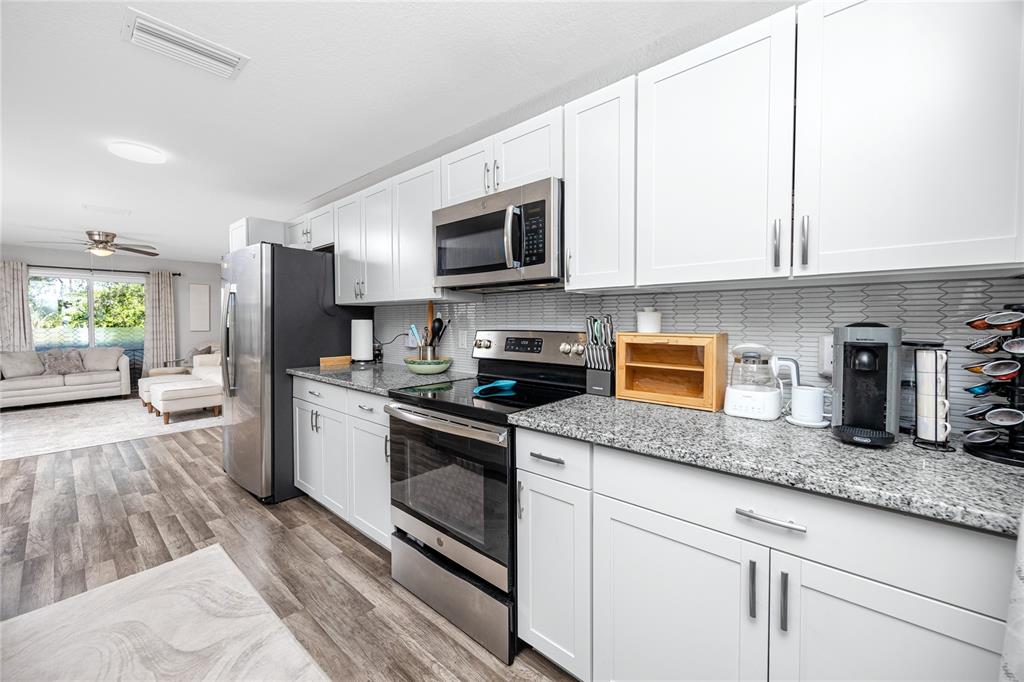 1869 Seton Drive Clearwater, FL 33763 - Photo 10 of 40 a kitchen with granite countertop a sink a stove and refrigerator