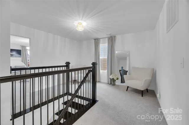 a view of a hallway with couches lamp and a chandelier