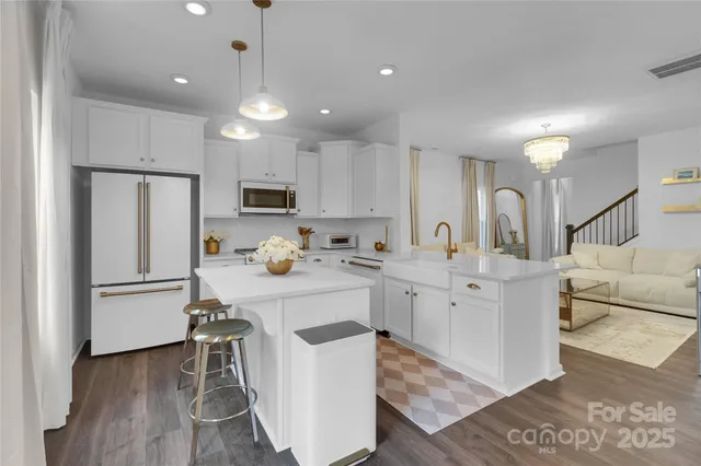a kitchen with white cabinets and stainless steel appliances