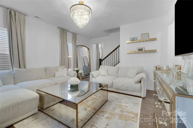 a living room with furniture a flat screen tv and a window