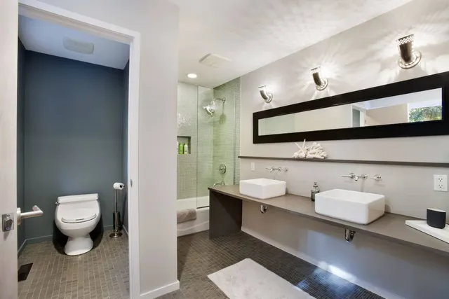 a bathroom with a toilet sink and mirror