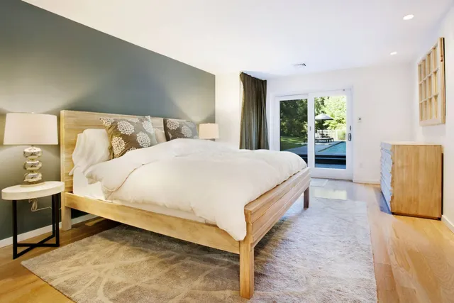 a bed sitting in a spacious bedroom next to a window