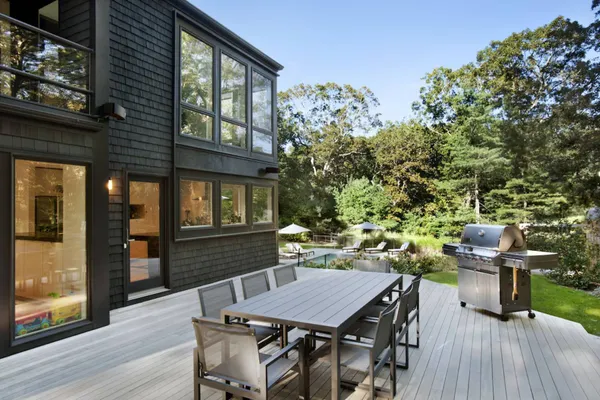 a view of a dinning table and chairs in patio of the house