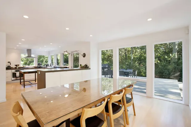 a dining room with furniture and a floor to ceiling window
