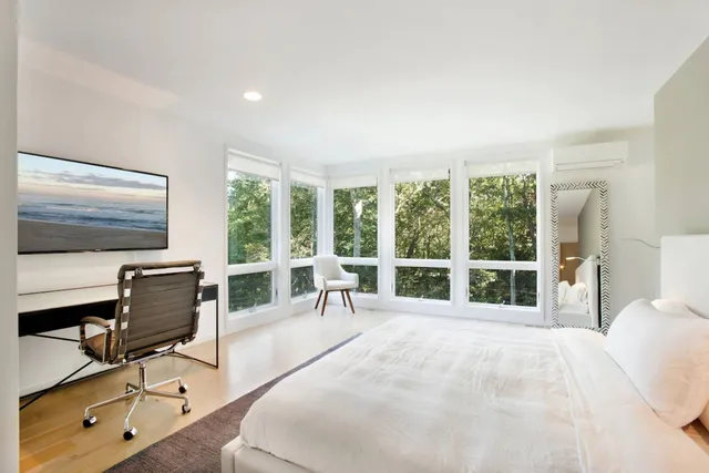 a bedroom with furniture and a large window