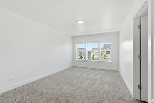 1173 West 1870 South Logan, UT 84321 - Photo 10 of 33 Room featuring light gray carpeting, crisp white walls, and a multi-pane window
