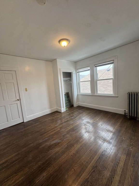 127 St Andrew Road, Unit 2 Boston, MA 02128 - Photo 10 of 15 an empty room with wooden floor and windows