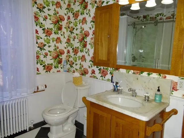 a bedroom with a bed and a flat tv screen next to a window