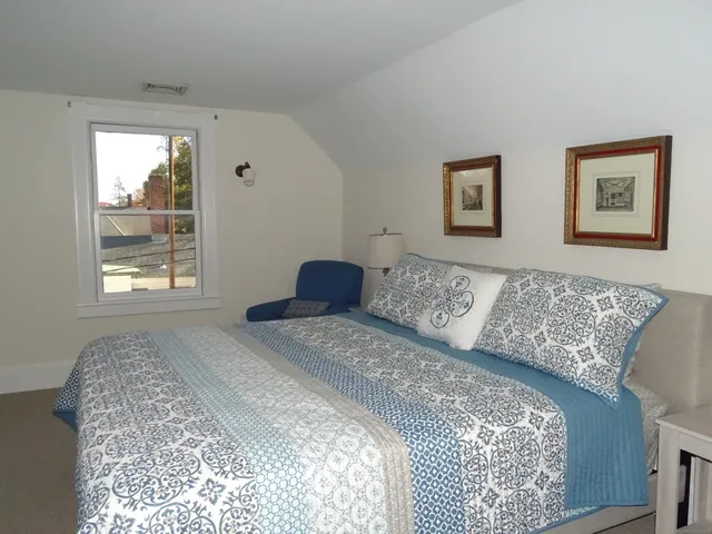 a bed sitting in a bedroom next to a window