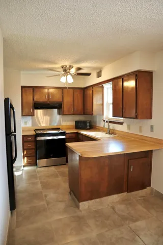 a kitchen with stainless steel appliances kitchen island granite countertop a sink and a stove