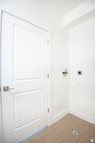 2085 North Main Street, Unit 412 Sunset, UT 84015 - Photo 8 of 14 Utility area featuring panel door with brushed nickel hardware, light wood-finish flooring, white baseboards, and bright white walls