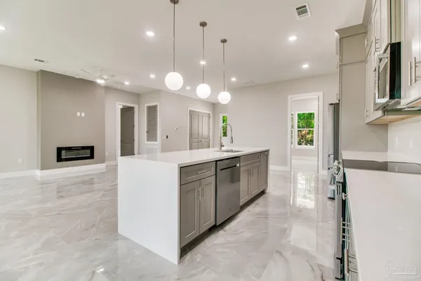 a large white kitchen with lots of counter space and a refrigerator