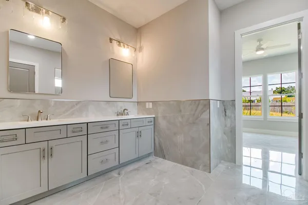 a spacious bathroom with double sink and mirror