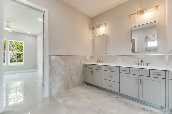 a spacious bathroom with a double vanity sink mirror and shower
