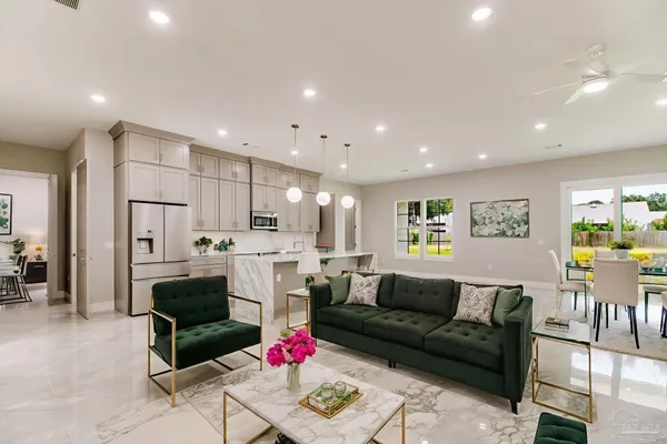 a living room with fireplace furniture and a dining table with kitchen view