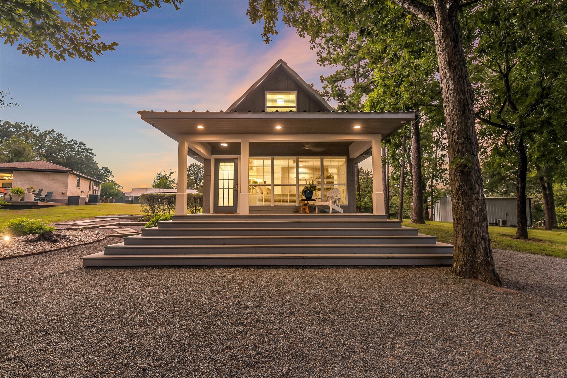 0 Camilla Lake Road Coldspring, TX 77331 - Photo 27 of 50 Cottage: Illuminated at dusk, the back entrance of the cottage welcomes you with an expansive covered porch, broad steps and a charming tree shaded setting.