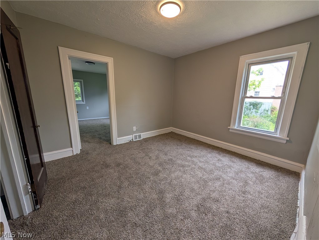 475 East 146th Street Cleveland, OH 44110 - Photo 16 of 28 Room featuring neutral tone carpeting, light gray wall paint, and white trim