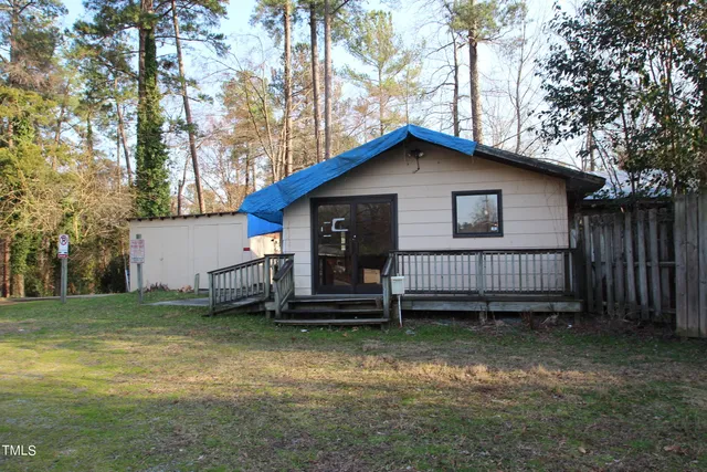 a view of a house with a yard and wooden fence