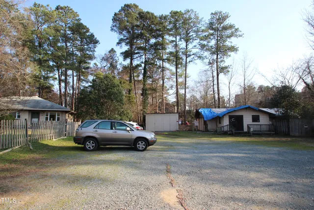 a front view of a house with garden and trees
