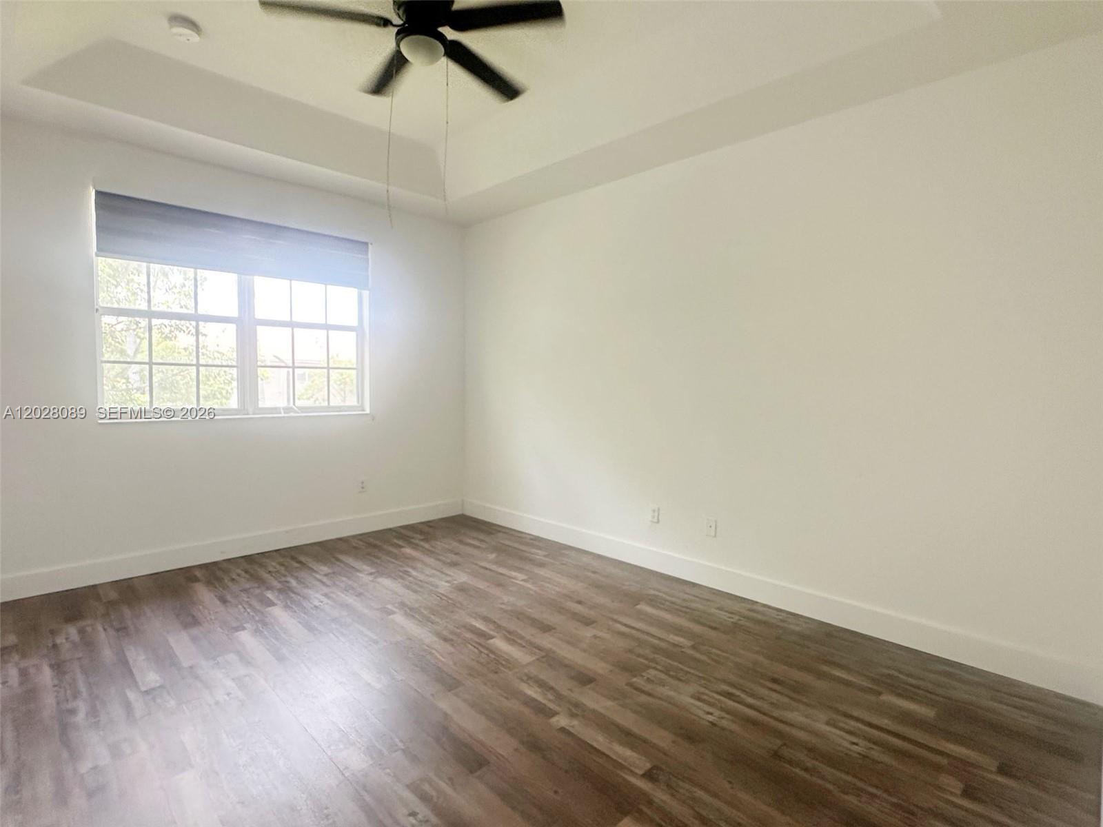 662 Northeast 21st Terrace Homestead, FL 33033 - Photo 13 of 34 an empty room with wooden floor fan and windows
